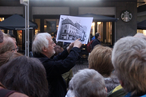 Führungsleiter zeigt altes Wohnhaus